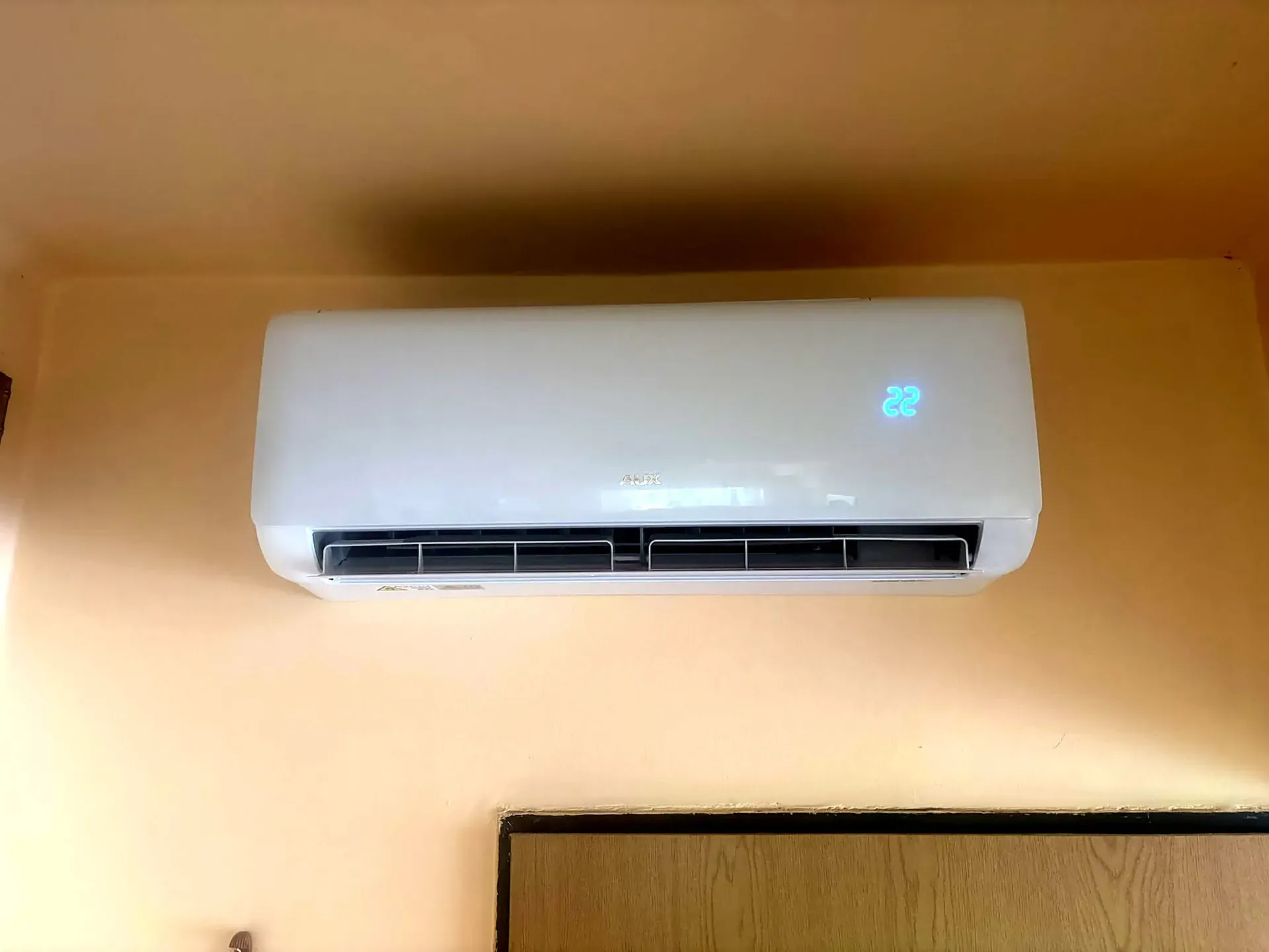 Nástenná klimatizácia AUX v byte s displejom nastaveným na 22 °C